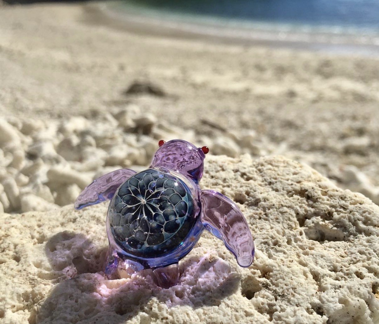 Purple handmade glass turtle on Miyakojima sand