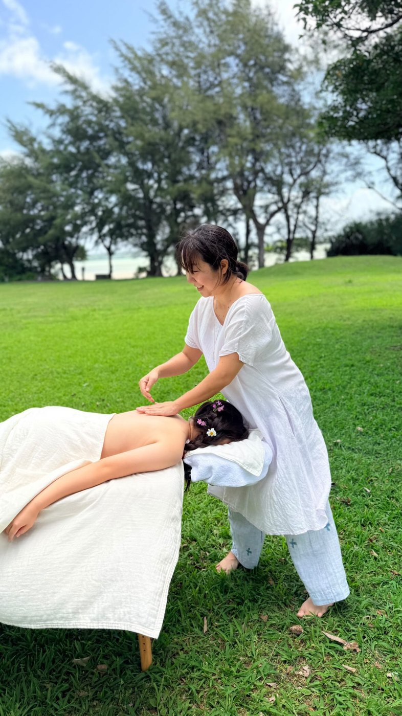 Therapist Nanami Sato giving lomi lomi outdoors in Miyakojima