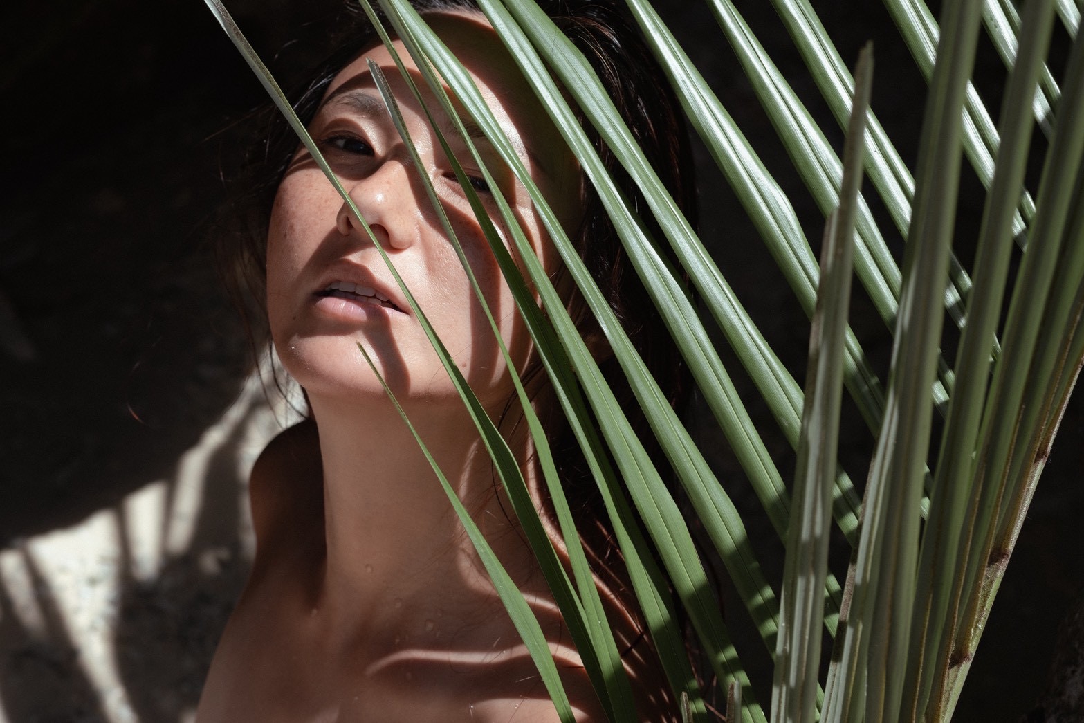 Portrait of Ran Numa framed by palm leaves
