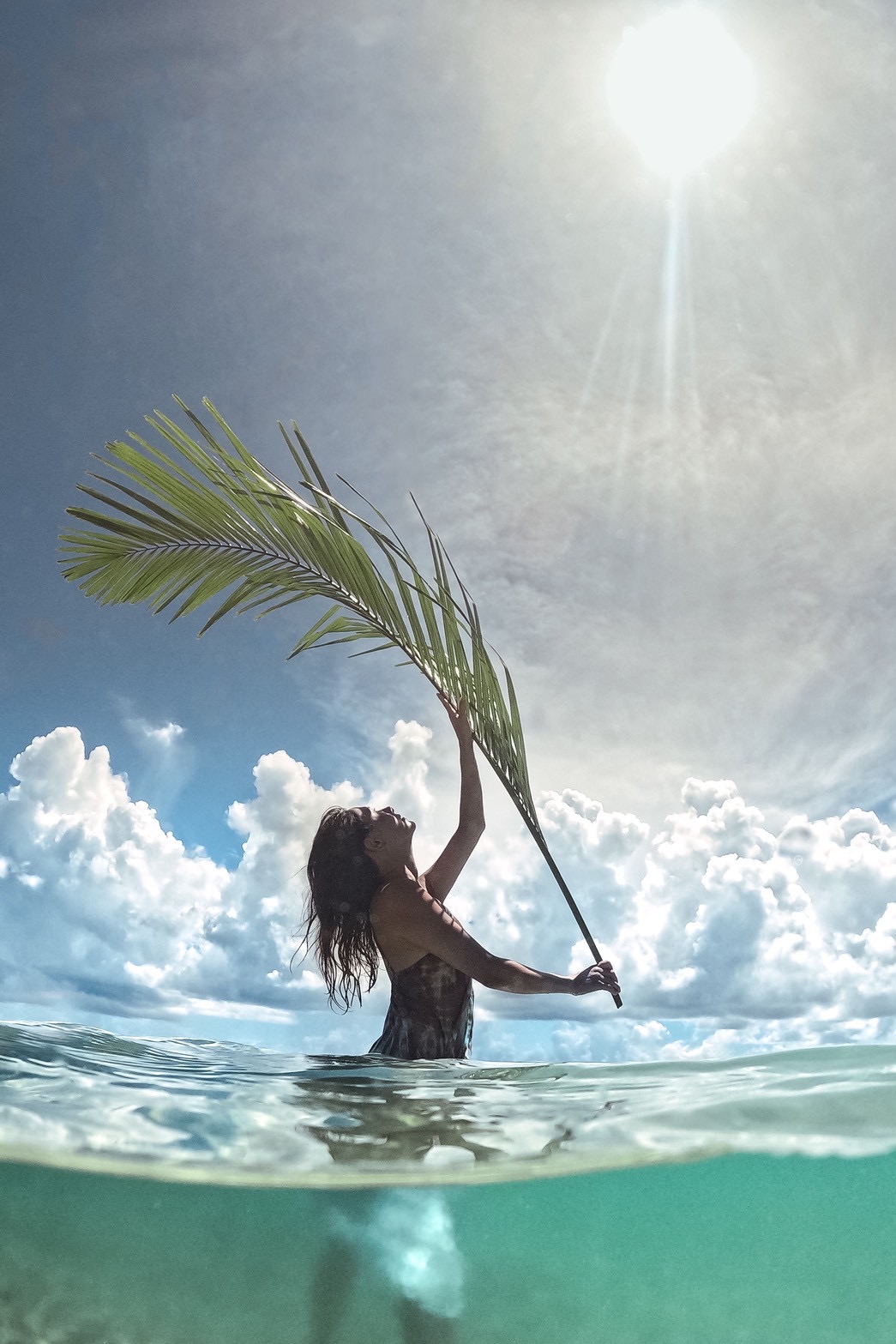 Ran holding a palm leaf in the Miyakojima sea